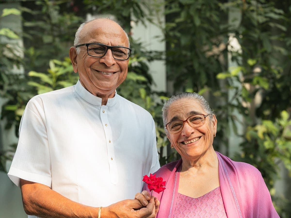 Smiling elderly couple standing together outdoors