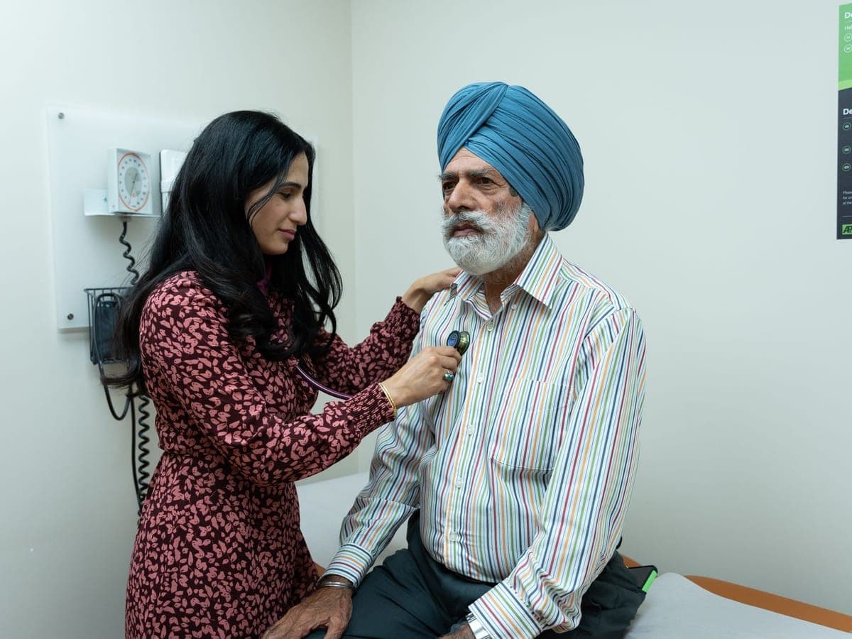 Doctor listening to an elderly man's chest with a stethoscope
